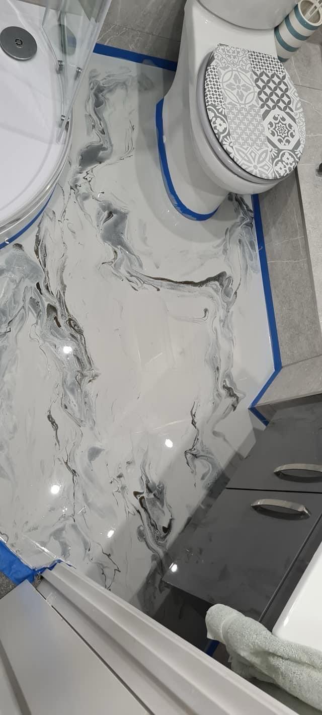 White and gray marble-look bathroom floor, blue tape still down